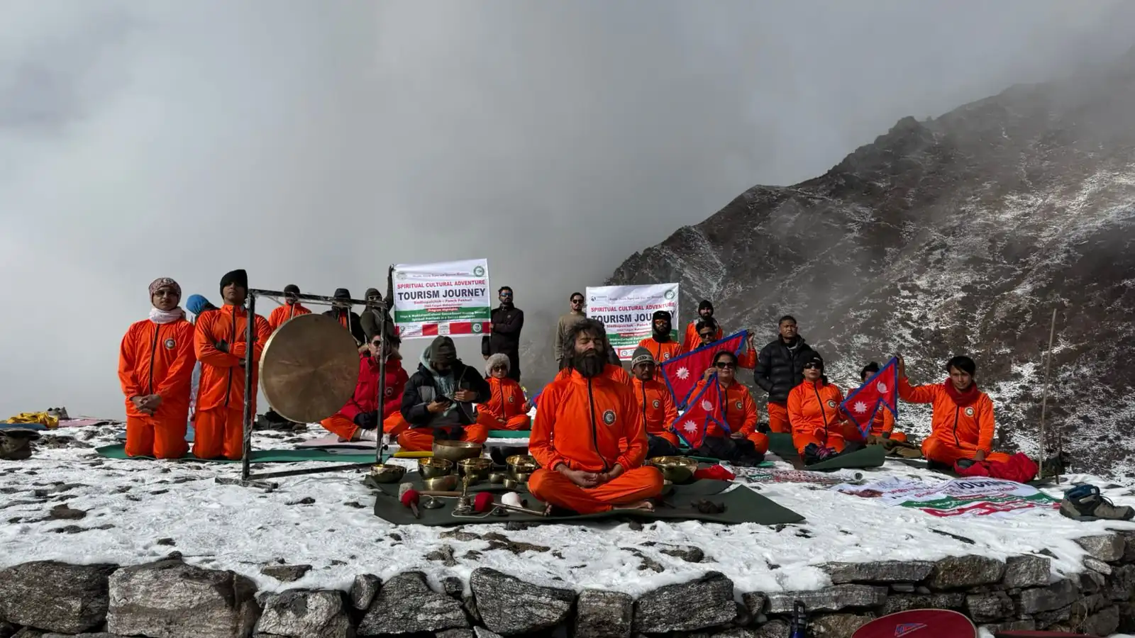 The Foundation's 2024 Himalayan camp, participants in saffron seated around a gong and offering table in the snow