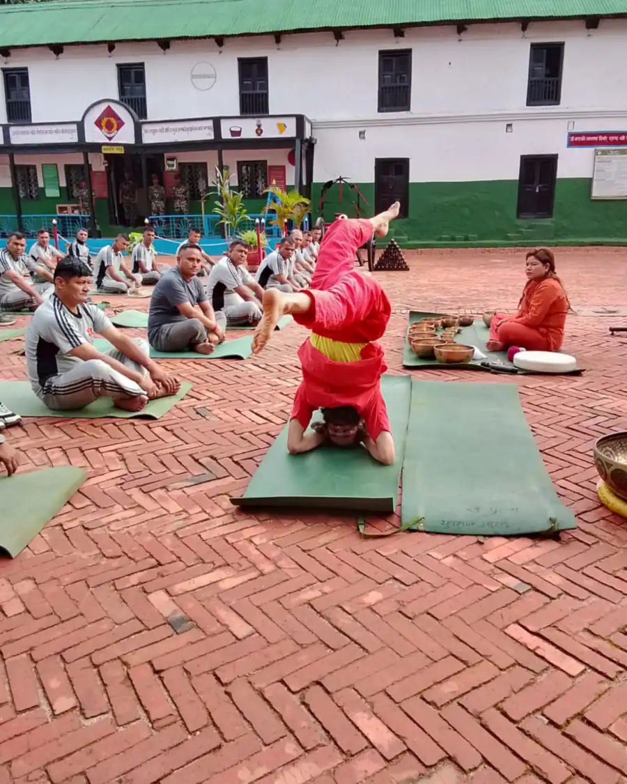 Yogi Ji leading a free outdoor session in a brick courtyard, participants seated on mats with singing bowls in front
